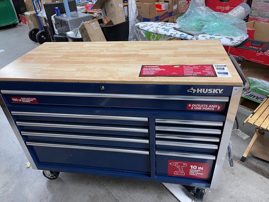 Husky 52 in. W x 24.5 in. D Standard Duty 10-Drawer Mobile Workbench Tool Chest with Solid Wood Work Top in Gloss Blue- brand new - has shipping dent at rear corner